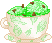 A tea cup with two scoops of mint chocolate chip ice cream. The cup is white with a green leaf pattern